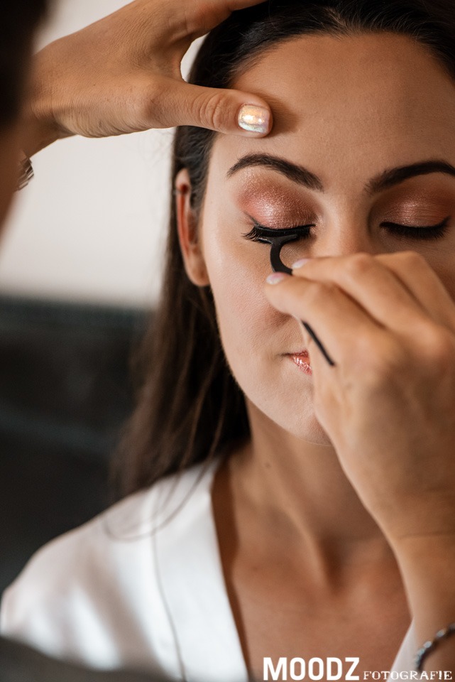 makeup wordt gedaan bij een bruid